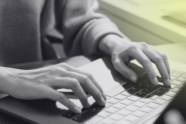A person working at a laptop on a desk, reviewing captions.