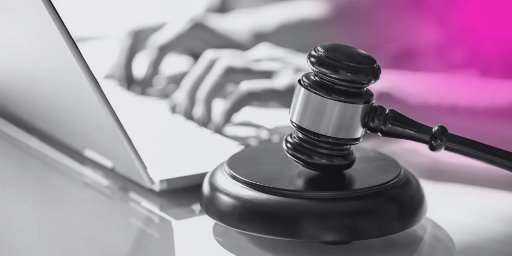 person on laptop with judge's gavel in the foreground