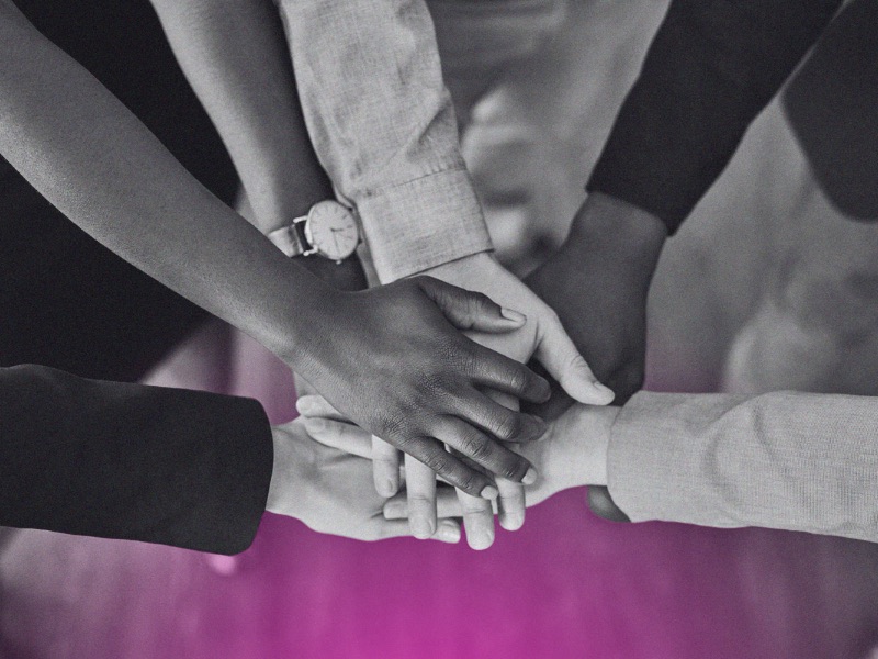 A team putting their hands together in a circle