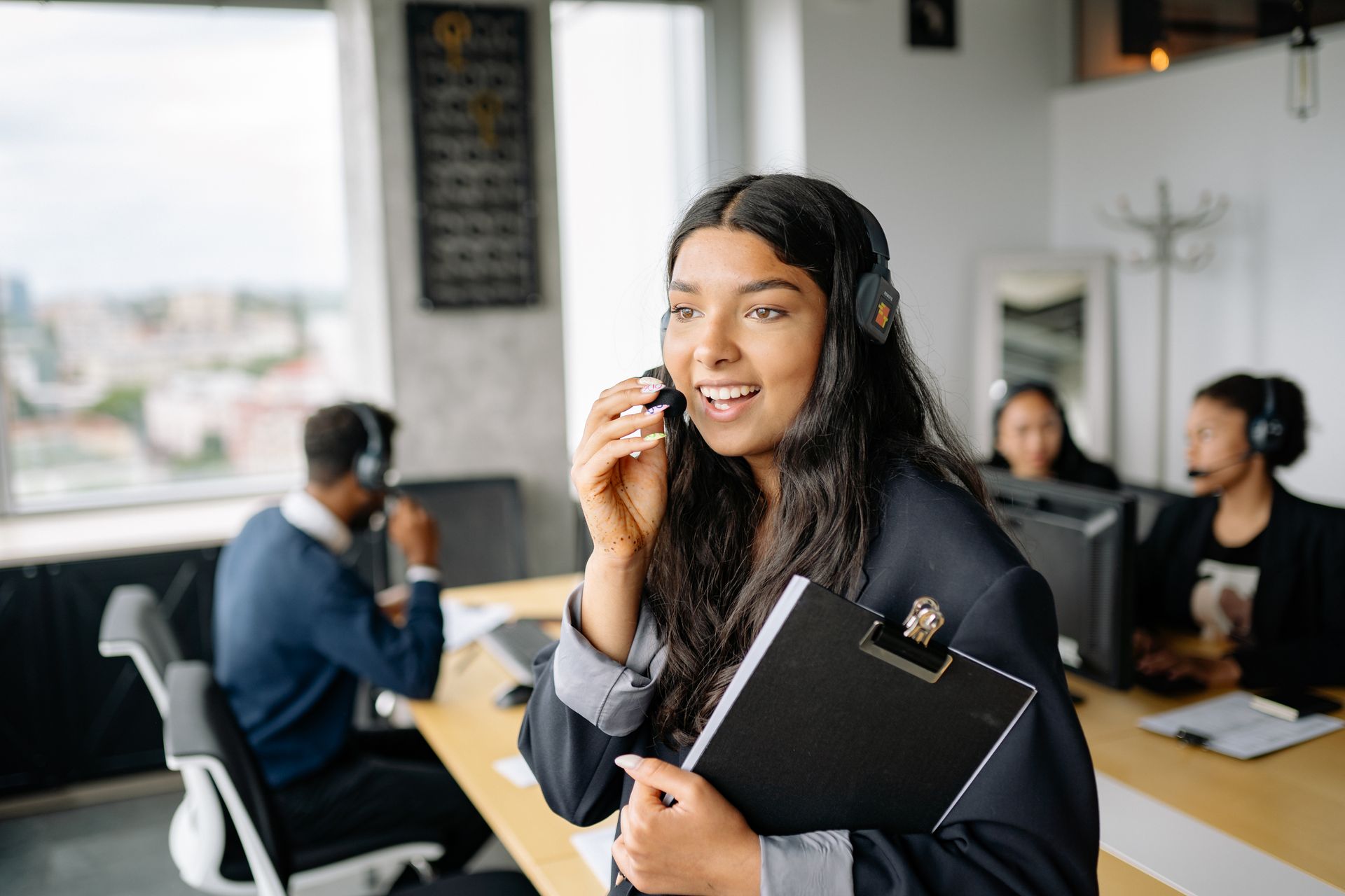 A customer service representative smiling while on a headset call.